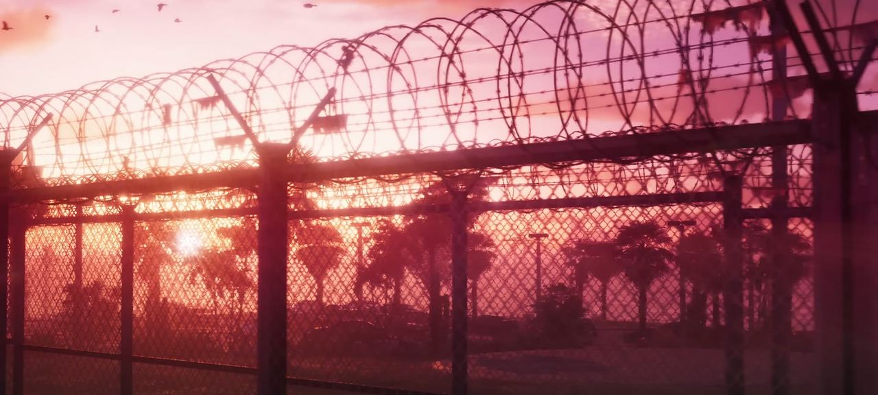 Razor wire over a fence at sunrise, shot into the light. Read at the time as a prison, and it was.