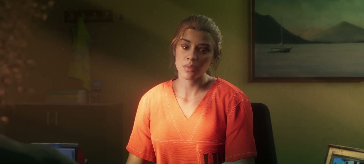 Lucia in an orange jumpsuit across a desk from an officer. The scene that introduced her.