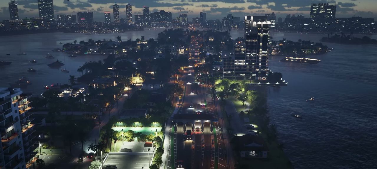 Aerial over the city at night, bridges and causeways lit.
