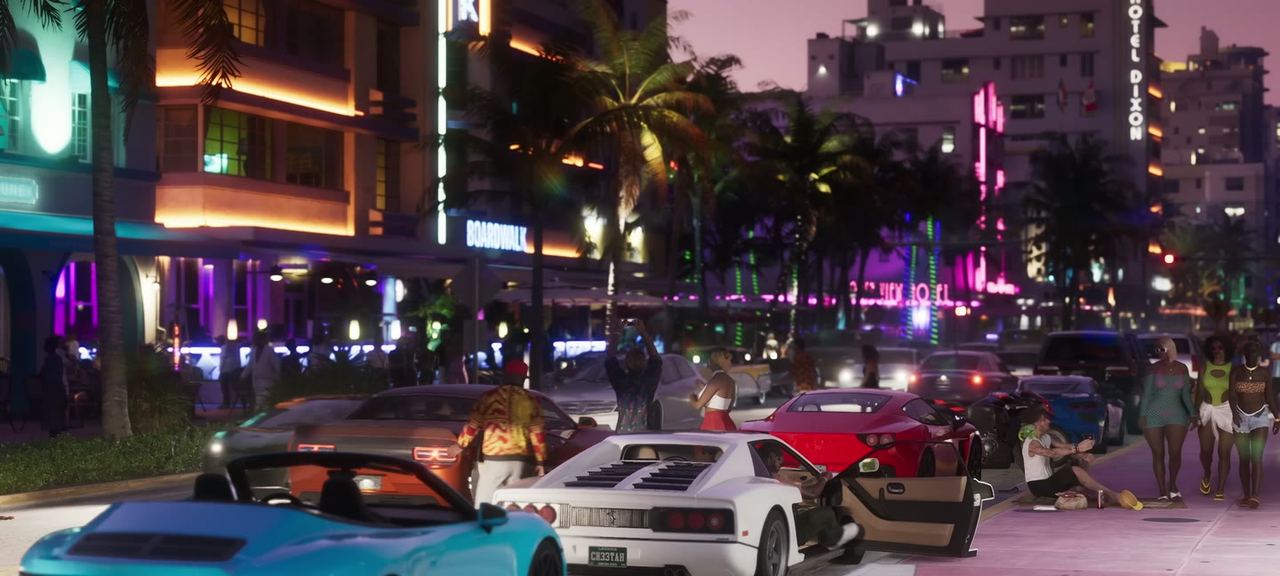 Ocean Drive at night. A white Cheetah with its door up and a CH33TAH plate, a turquoise convertible, a red coupe.