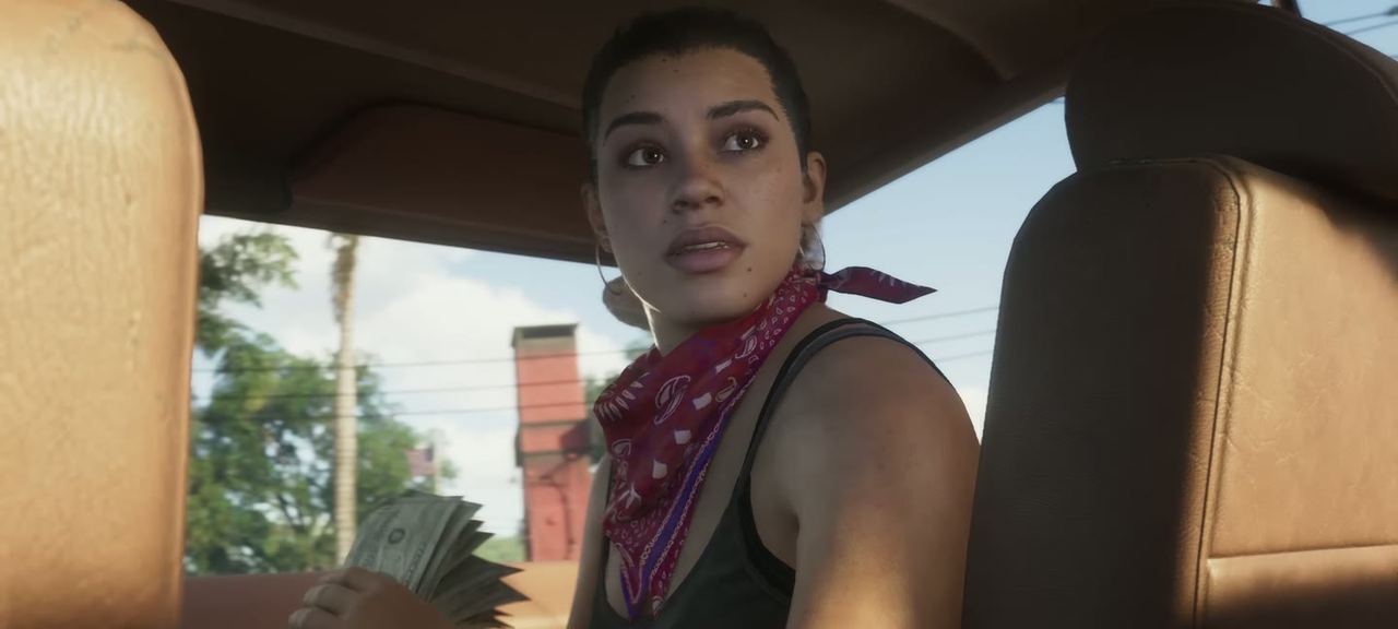 A woman in a bandana turning in the passenger seat.