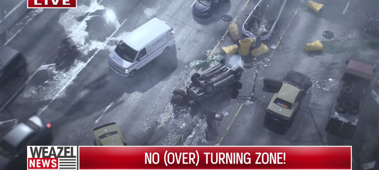 News helicopter footage of a flipped car surrounded by police, captioned NO (OVER) TURNING ZONE.