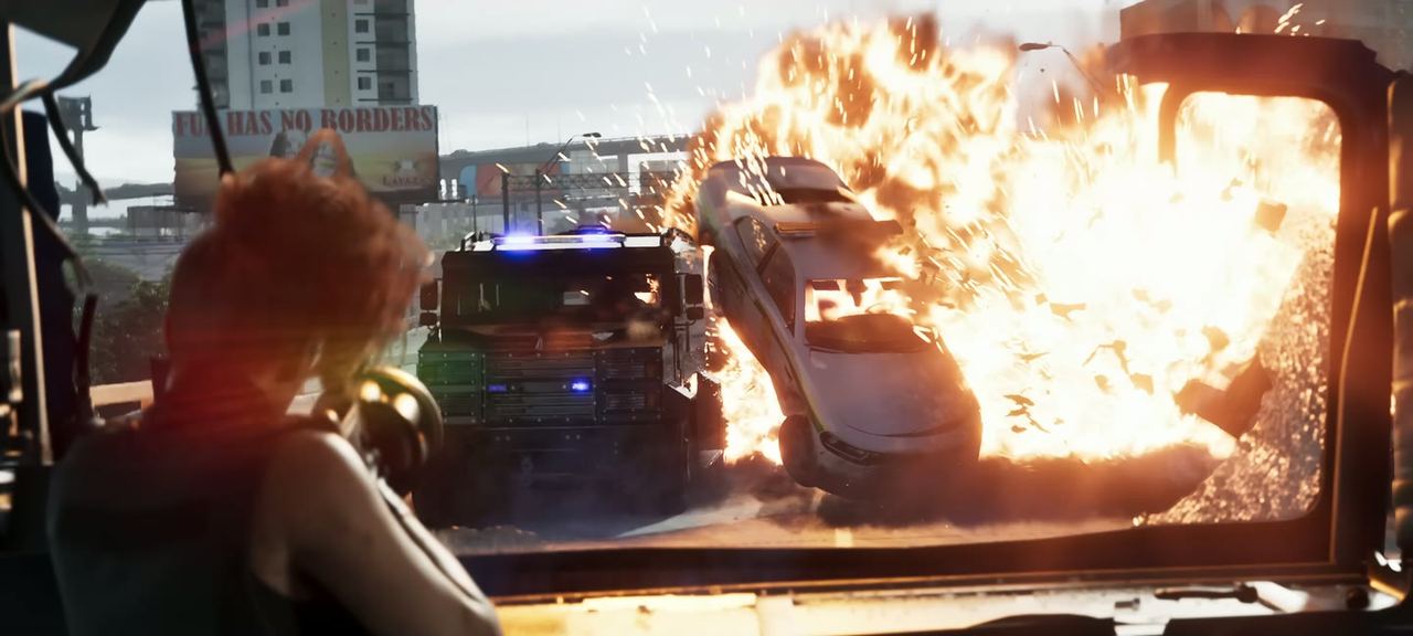 A car fully alight beside police vehicles with their lights going.