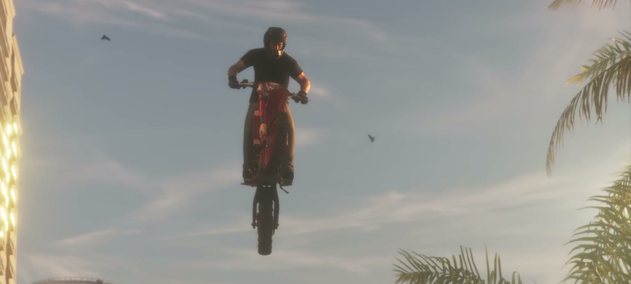 A rider on a dirt bike in mid-air between hotel towers. Nothing says this is a race